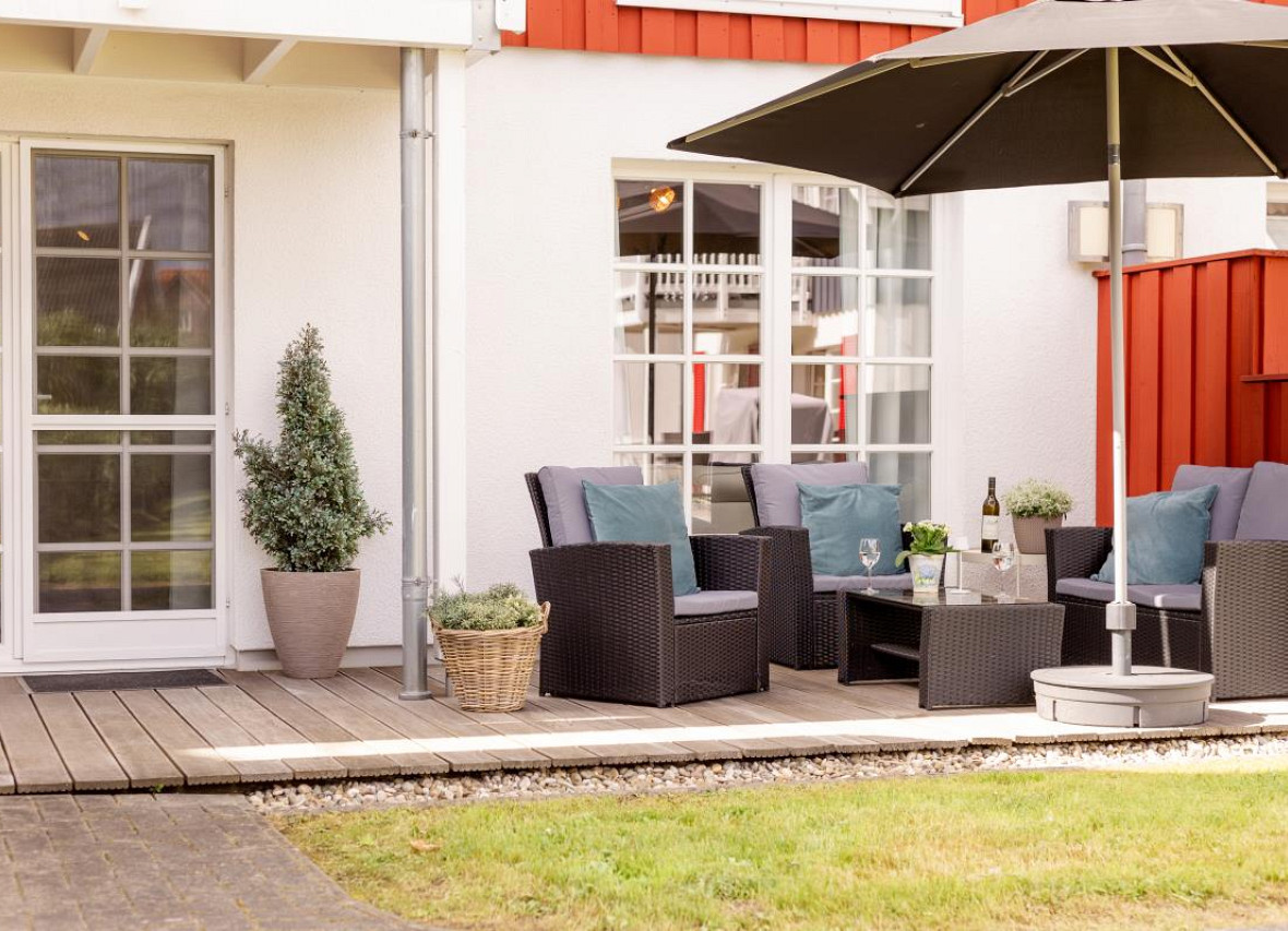 Gemütliche Terrasse an der Ferienwohnung Seestern in Greetsiel mit Loungemöbeln und Sonnenschirm