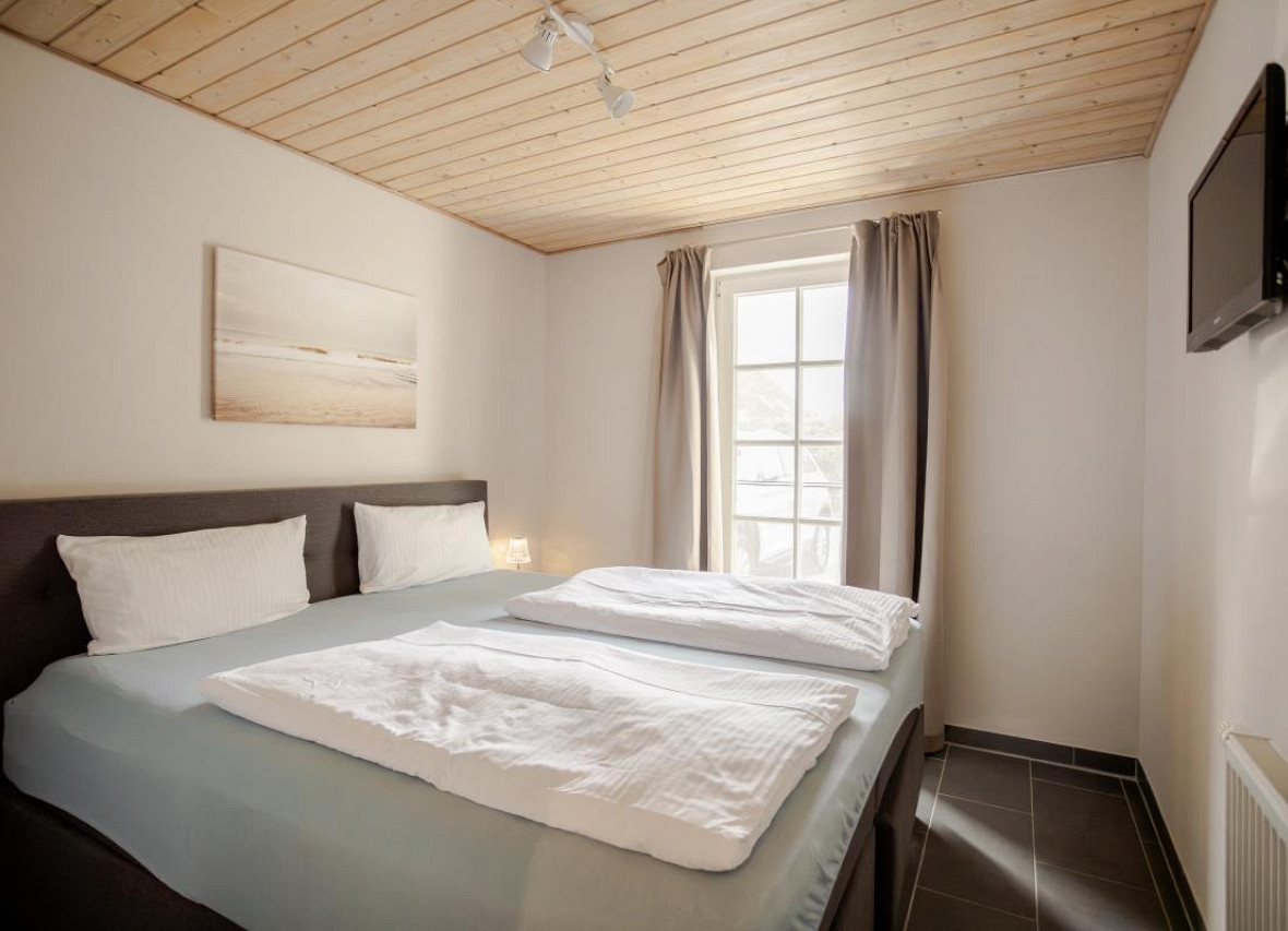 Helles Schlafzimmer mit Doppelbett im Ferienhaus Seestern in Greetsiel